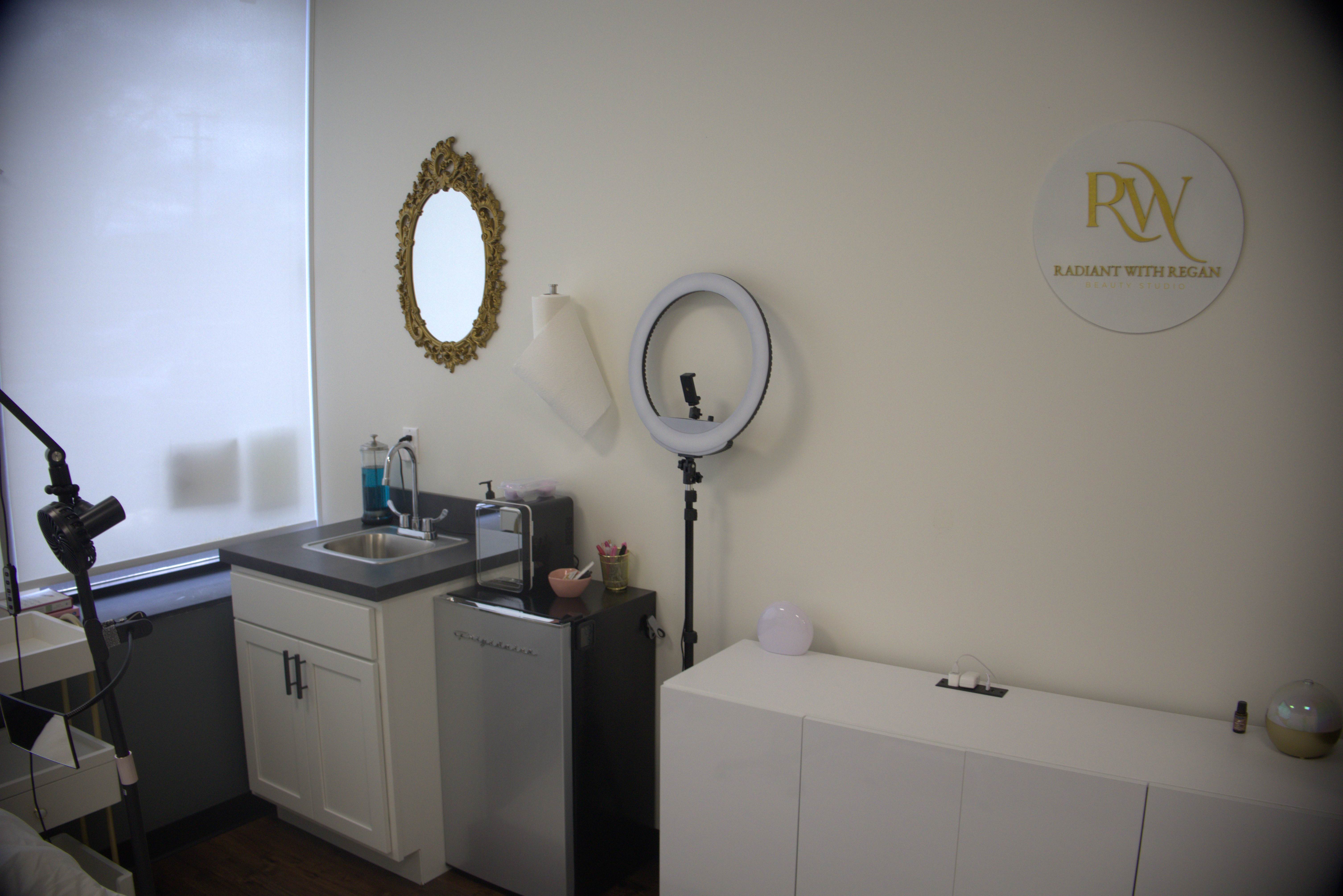 Professional treatment room with sink area and ring light