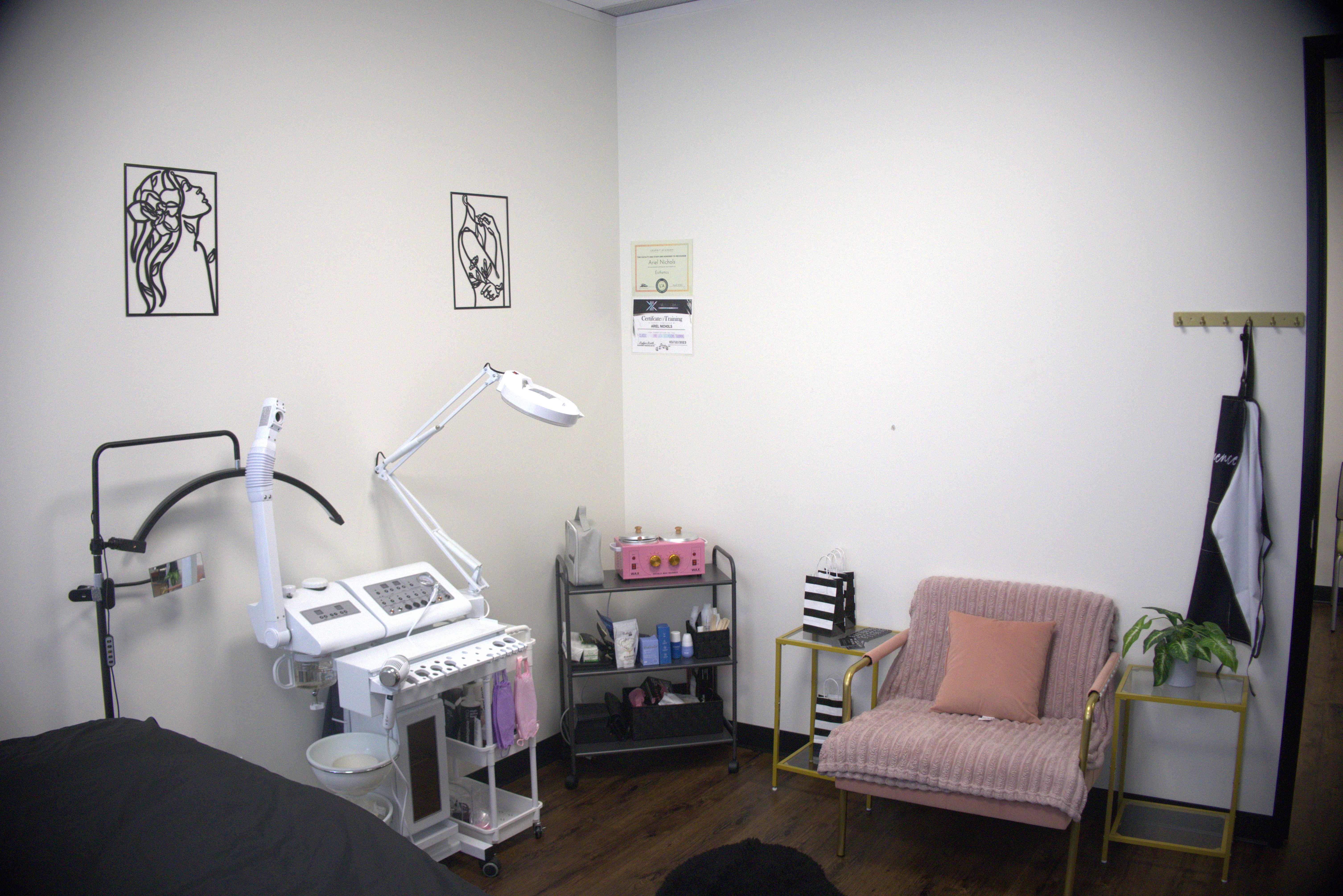 Aesthetic treatment room with pink seating and professional equipment