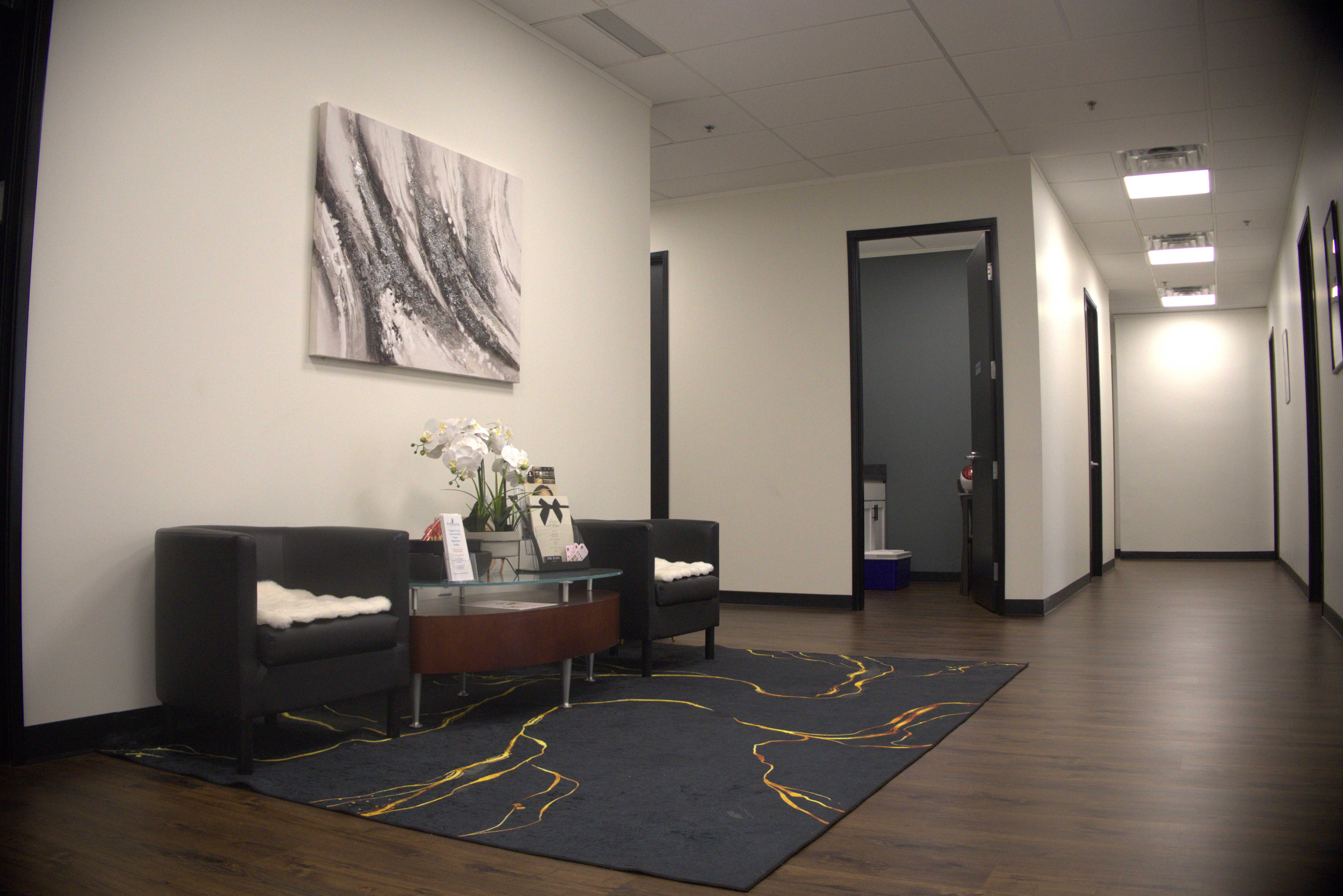 Modern waiting area with contemporary artwork and elegant gold-accented rug