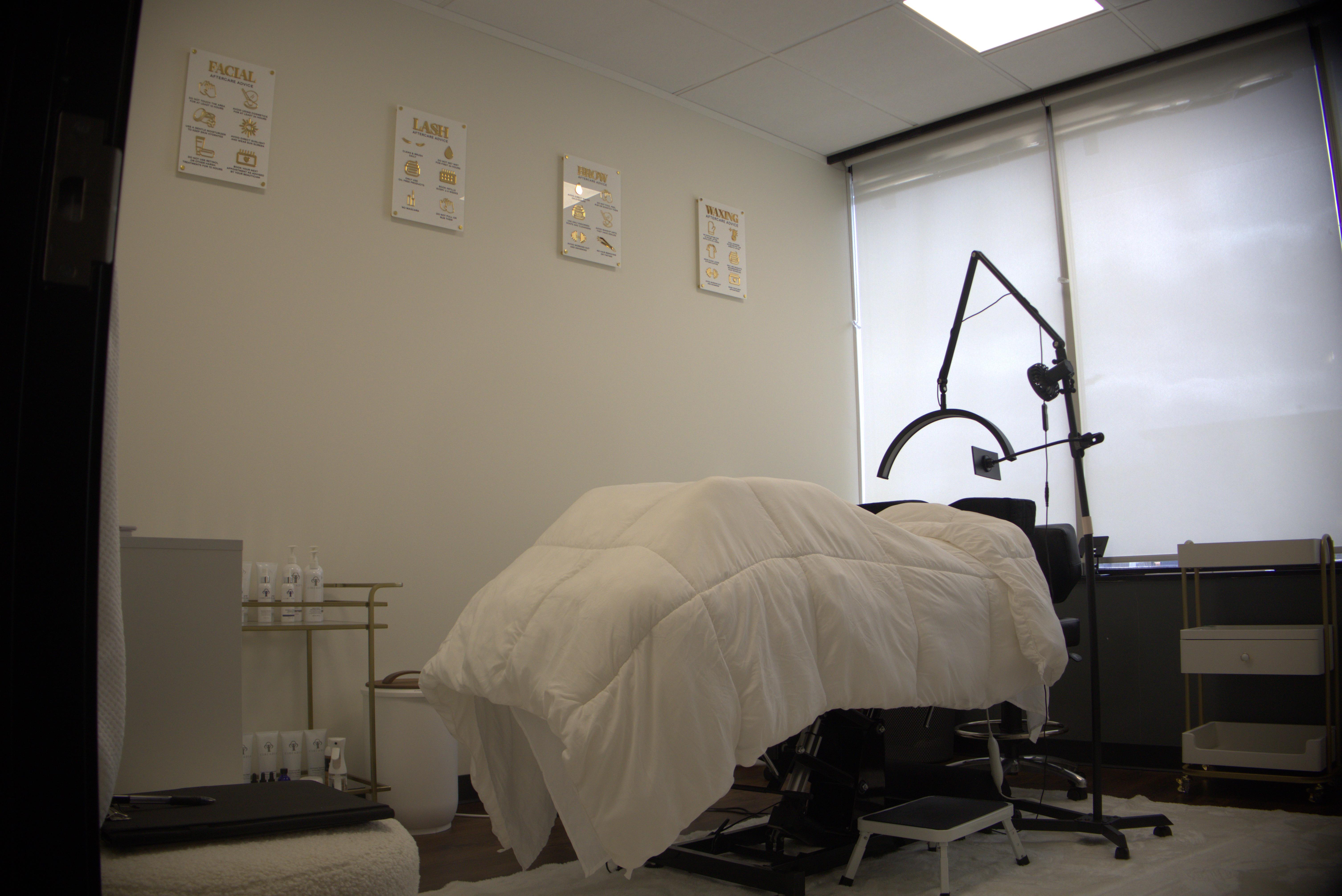 Spa treatment room with professional facial equipment and therapy charts